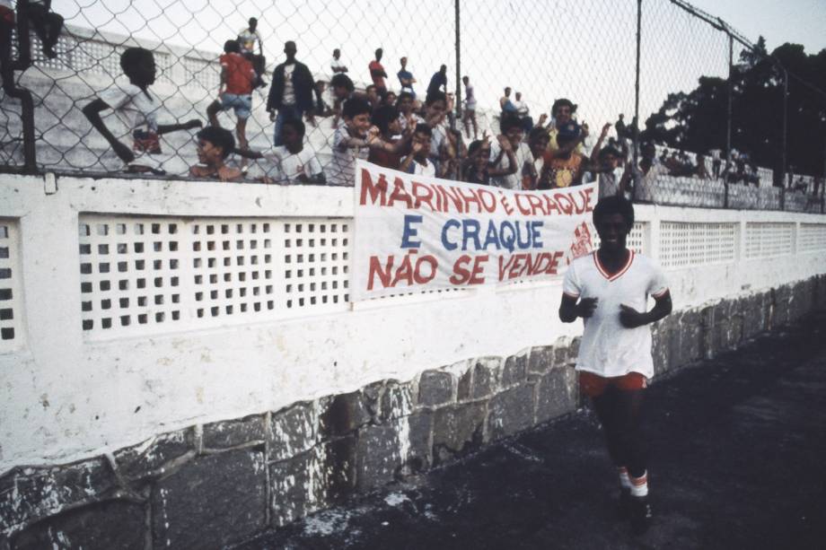 Marinho passando em frente a uma faixa com os dizeres "Marinho é craque e craque não se vende", em 1985