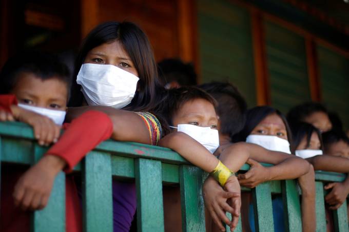 Children from the indigenous Yanomami ethnic group wearing protective face mask look on, amid the spread of the coronavirus disease (COVID-19), at the 5th Special Frontier Platoon in the municipality of Auaris