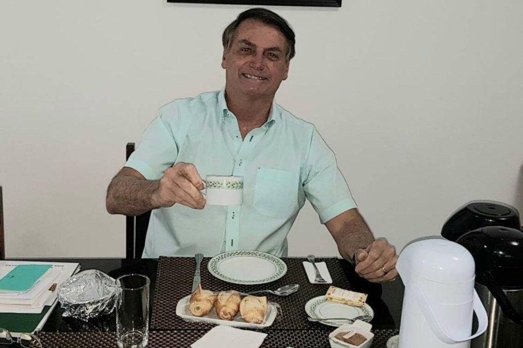 Infectado com Covid-19, o presidente Jair Bolsonaro posa para foto durante o café da manhã sem usar máscara -