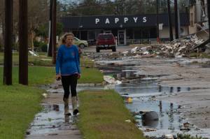 Uma mulher anda pelos escombros deixados no chão após a passagem do furacão Laura, em Louisiana - 27/08/2020