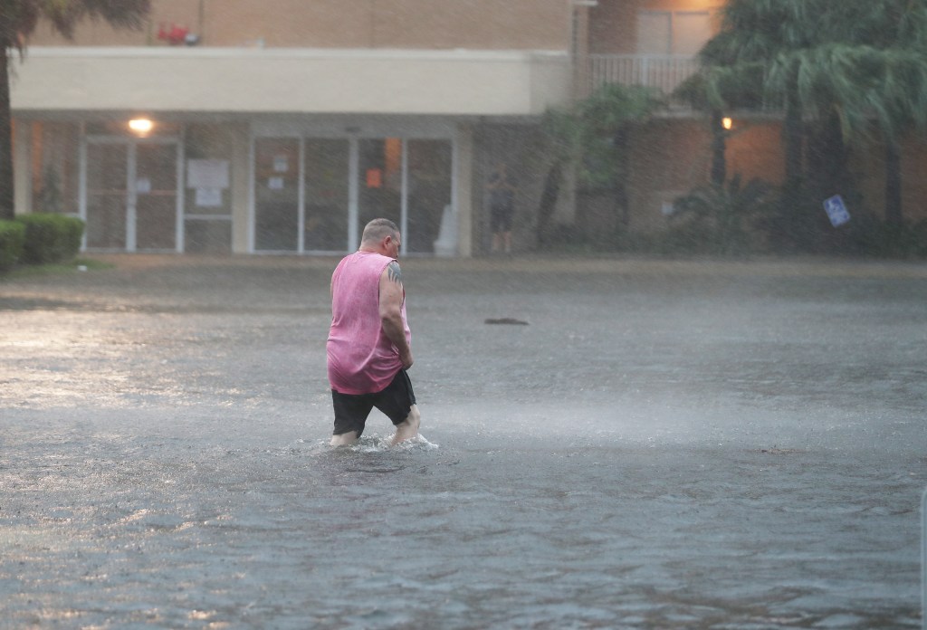 Homem anda em rua alagada pelo furacão Sally em Gulf Shores, Alabama. 15/08/2020