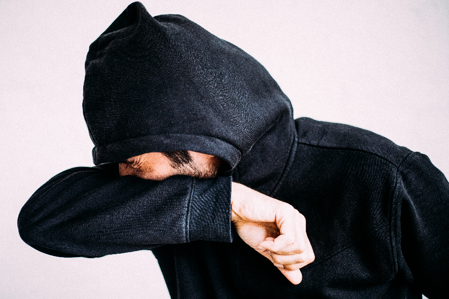 Homem espirrando no braço