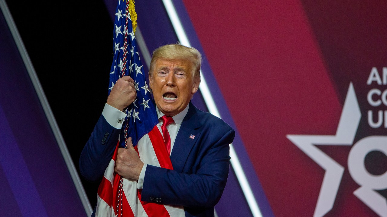 O presidente dos Estados Unidos, Donald Trump, abraçou a bandeira do país durante a Conferência de Ação Política Conservadora (CPAC) - 29/02/2020