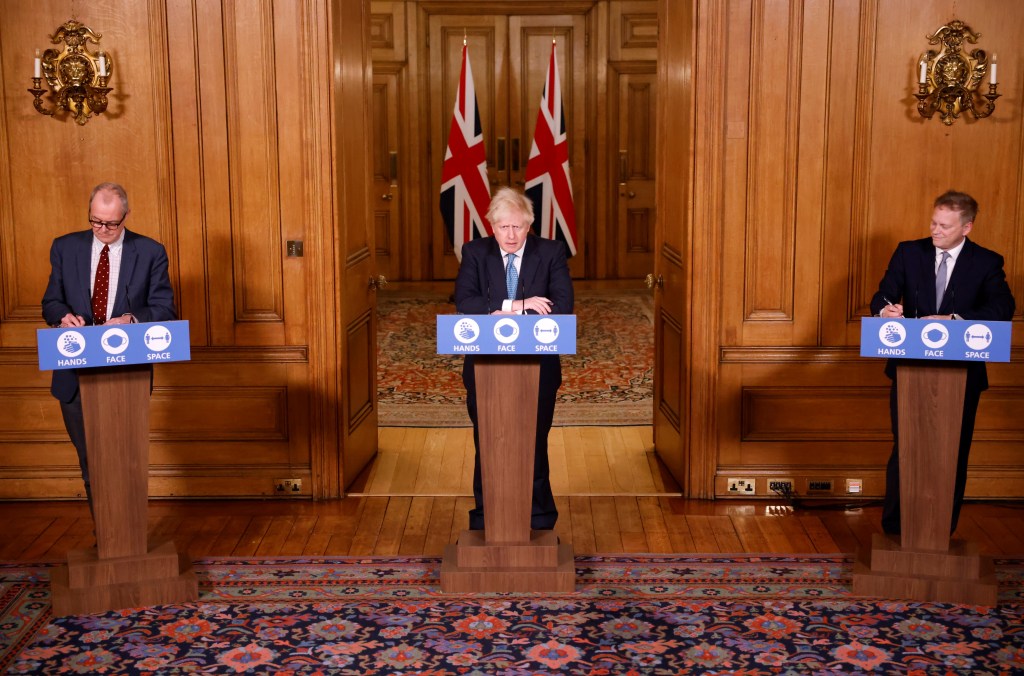 Primeiro-ministro do Reino Unido, Boris Johnson, o secretário dos Transportes, Grant Shapps, e o chefe do Comitê Científico britânico, Patrick Vallance, reunidos em entrevista coletiva nesta segunda-feira 21