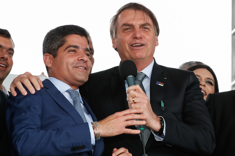 O que ACM Neto tem a ganhar indo tão à direita na Bahia - Na imagem o presidente Jair Bolsona está ao lado de ACM Neto segurando o microfone juntos.