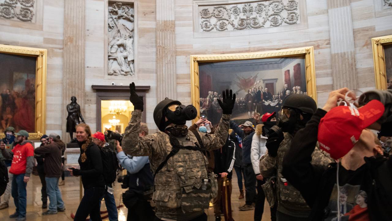 Apoiadores de Trump durante invasão ao Capitólio com quadro Declaração de Independência, de John Trumbull ao fundo