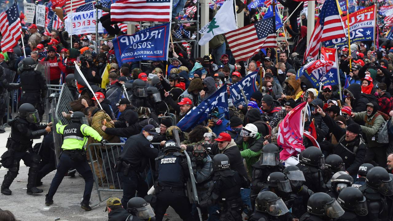 Trump supporters clash with police and security forces as they push barricades to storm the US Capitol in Washington D.C on January 6, 2021. - Demonstrators breeched security and entered the Capitol as Congress debated the a 2020 presidential election Electoral Vote Certification. (Photo by ROBERTO SCHMIDT / AFP)