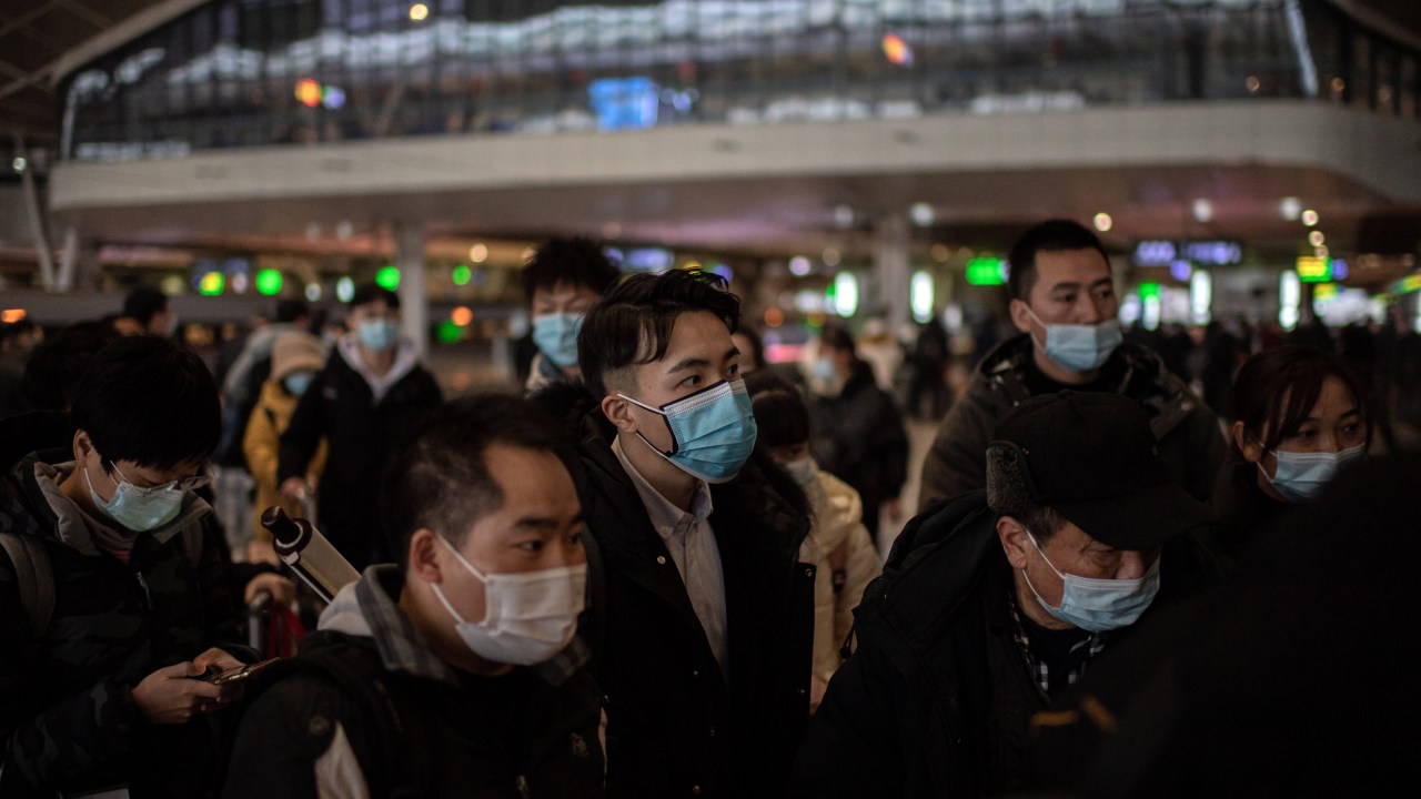Pedestres com máscaras vistos em estação de trem em Wuhan, China. 10/01/2021