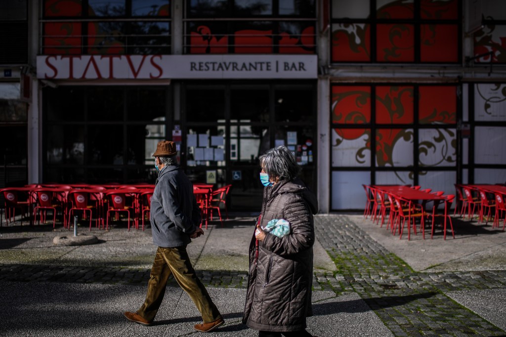 Casal caminha perto de restaurante fechado no Parque das Nações, Lisboa. 22/01/2021