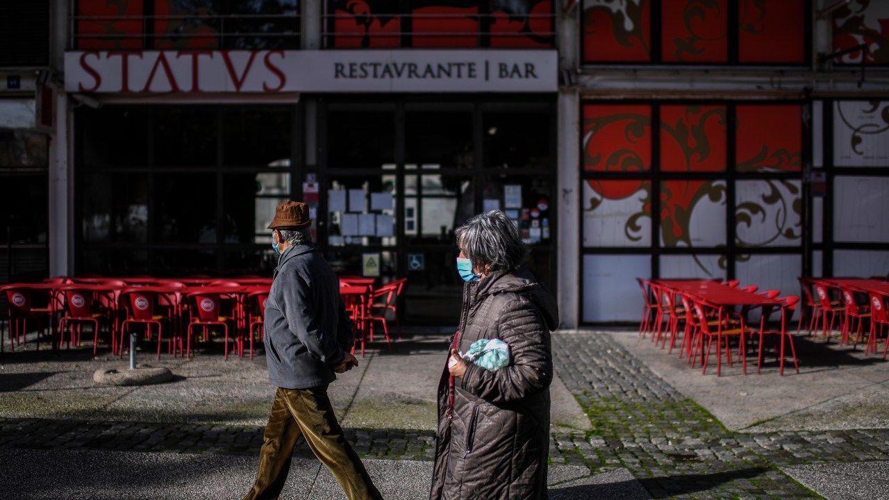 Casal caminha perto de restaurante fechado no Parque das Nações, Lisboa. 22/01/2021