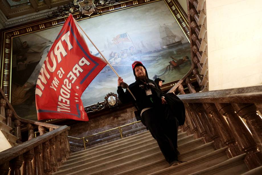 Um manifestante segura uma bandeira pró-Trump dentro do edifício do Capitólio, nos EUA -