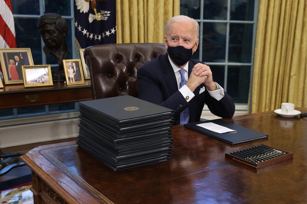 WASHINGTON, DC - JANUARY 20: U.S. President Joe Biden prepares to sign a series of executive orders at the Resolute Desk in the Oval Office just hours after his inauguration on January 20, 2021 in Washington, DC. Biden became the 46th president of the United States earlier today during the ceremony at the U.S. Capitol. Chip Somodevilla/Getty Images/AFP