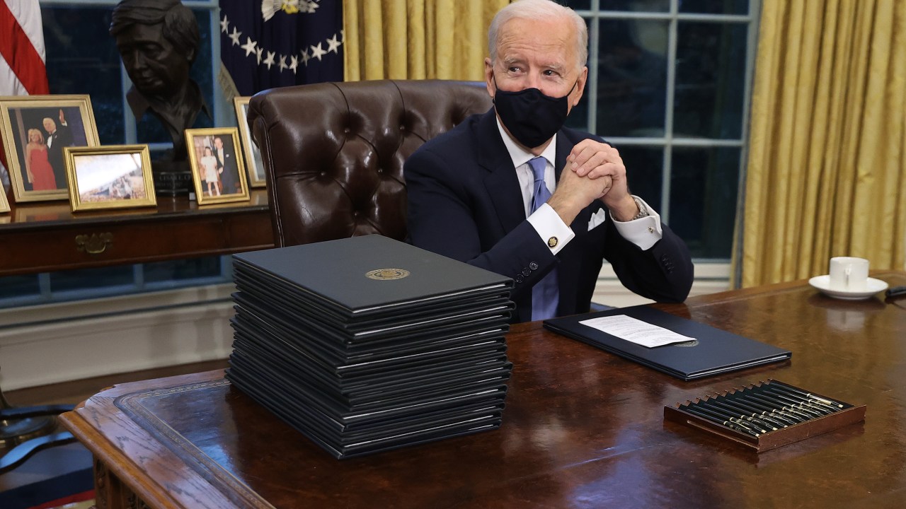 WASHINGTON, DC - JANUARY 20: U.S. President Joe Biden prepares to sign a series of executive orders at the Resolute Desk in the Oval Office just hours after his inauguration on January 20, 2021 in Washington, DC. Biden became the 46th president of the United States earlier today during the ceremony at the U.S. Capitol. Chip Somodevilla/Getty Images/AFP