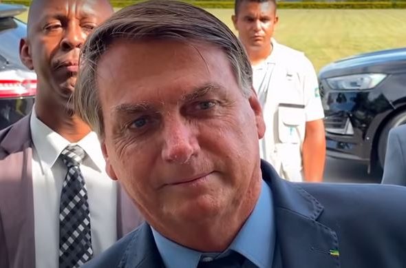 O presidente Jair Bolsonaro posa para foto de apoiador em frente ao Palácio da Alvorada