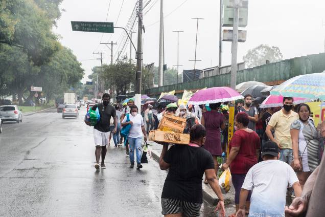 Sob chuva, muitos ainda esperavam para entrar na Ceagesp para retirar seus kits - Sob chuva, muitos ainda esperavam para entrar na Ceagesp para retirar seus kits -