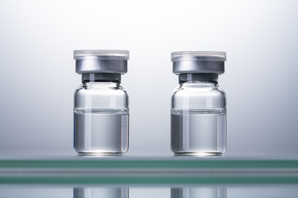 Two Sealed Airtight Medical Vials Against Bright Background Front View.