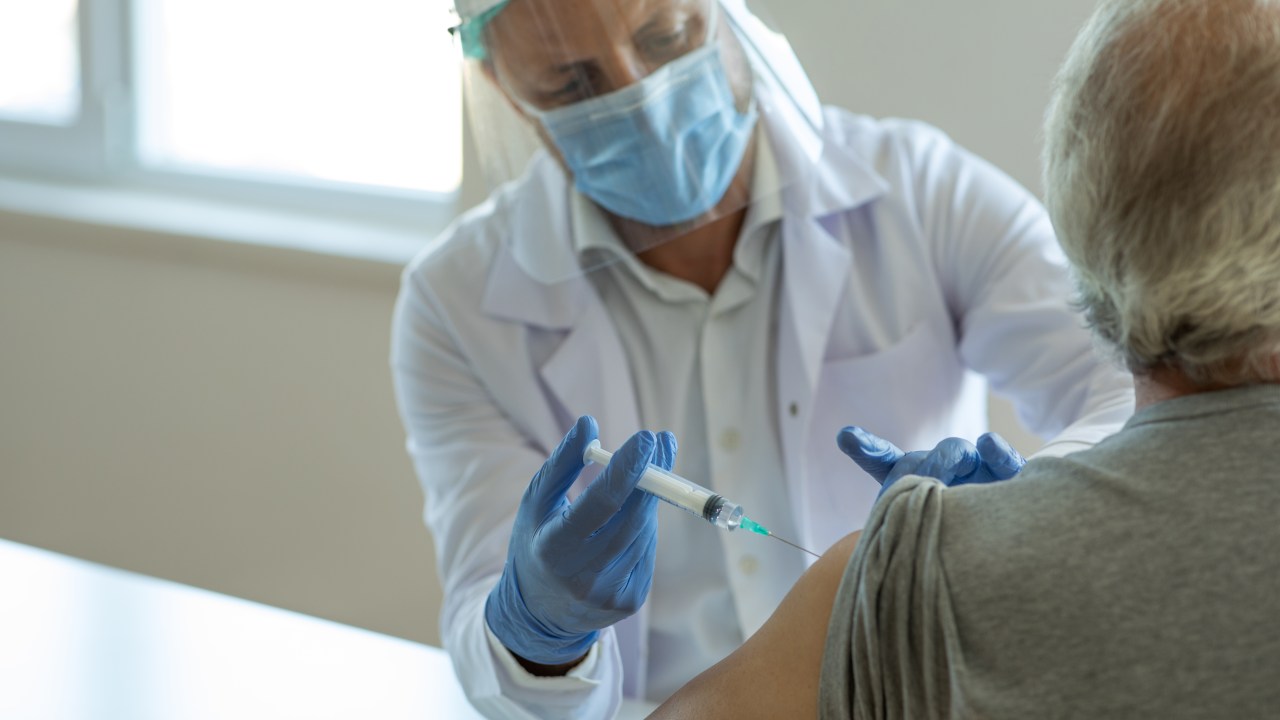 Injecting flu vaccine into patient's arm
