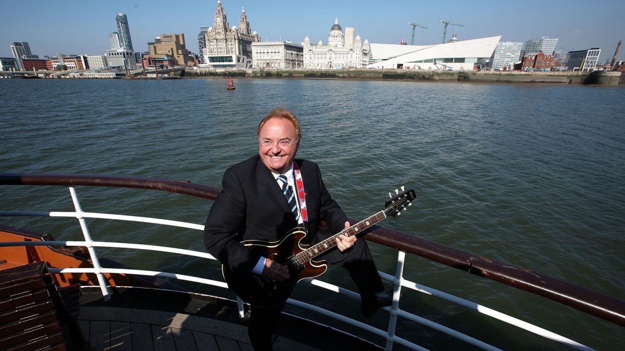 Gerry Marsden a bordo de um barco no rio Mersey, em Liverpool, que ele popularizou com a música 'Ferry Across the Mersey'