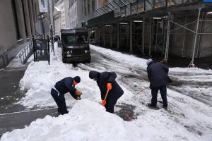 Os trabalhadores limpam as ruas de neve em Manhattan em 2 de fevereiro. Nova York e grande parte do nordeste dos UE estão sendo atingidas por uma grande tempestade de inverno que trouxe mais de meio metro de neve para a área antes do fim da tarde de terça-feira. Escolas, transporte público e centros de vacinas em toda a região estão sendo afetados pela tempestade.