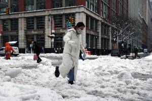 Pedestres em rua repleta de neve em Manhattan, Nova York. 02/02/2021