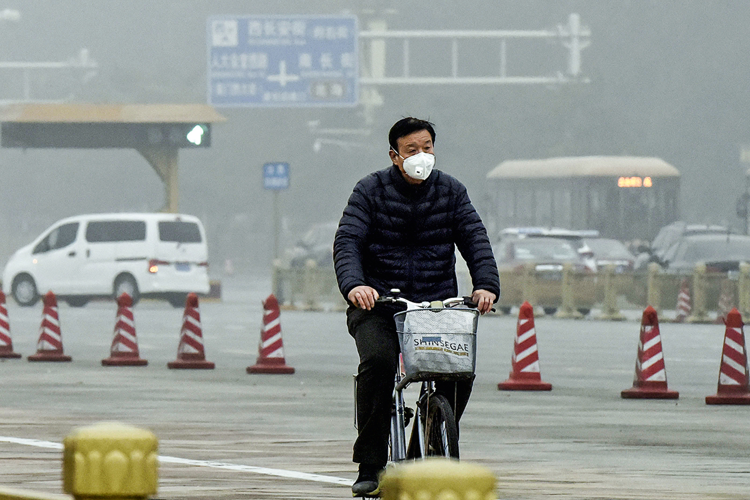 ATAQUE AOS PULMÕES - Ciclista em Pequim: morador pedala de máscara para se proteger da poluição -