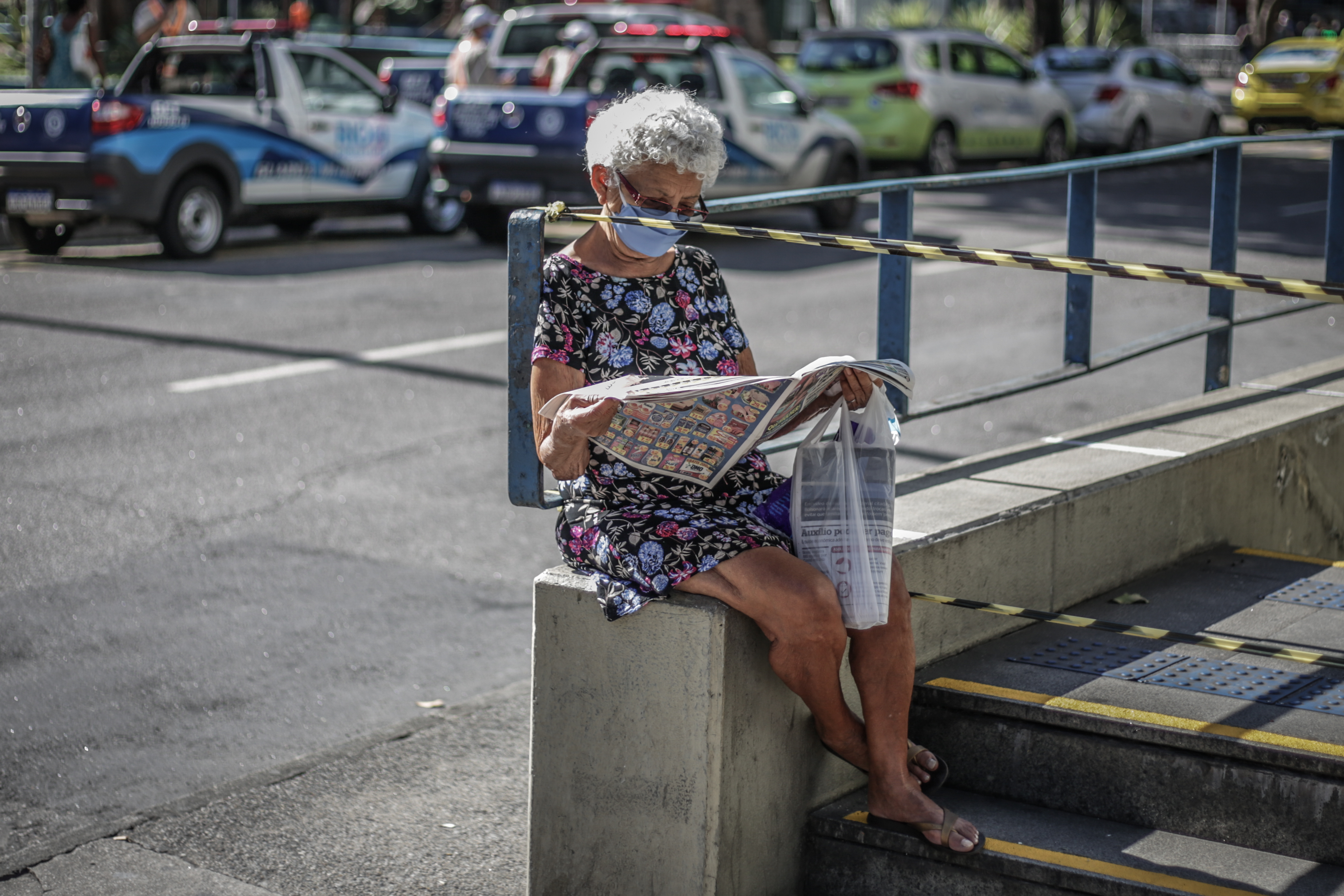 Mulher com máscara de proteção lê jornal na Tijuca, Rio de Janeiro. 13/05/2020