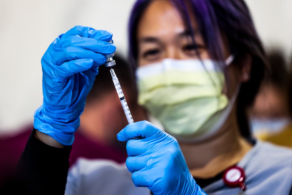 DENVER, CO - FEBRUARY 20: UCHealth pharmacist Marissa Kim prepares a dose of the Pfizer-BioNTech COVID-19 vaccine during a mass vaccination event in the parking lot of Coors Field on February 20, 2021 in Denver, Colorado. UCHealth plans to administer 10,000 second doses to seniors over 70 during the drive-up event this weekend. (Photo by Michael Ciaglo/Getty Images)
