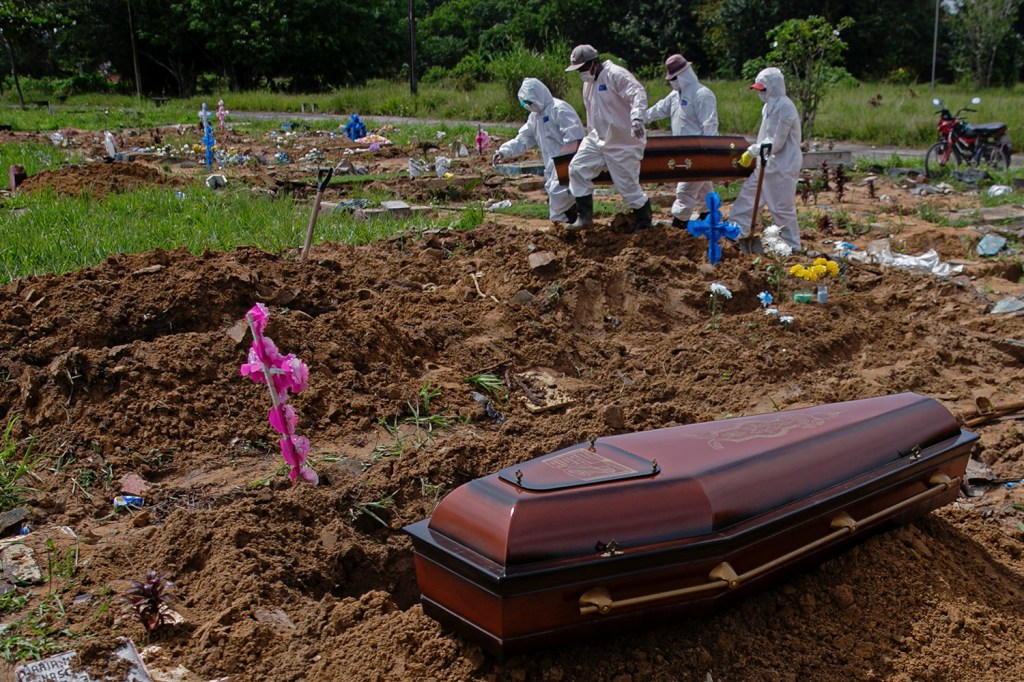 Coveiros do cemitério público Parque Tapana carregam o caixão de uma vítima de COVID-19 antes de enterrá-lo, em Belém, no estado do Pará -