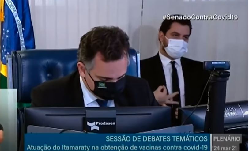 O assessor internacional de Bolsonaro, Filipe Martins, faz gesto considerado supremacista enquanto o presidente do Senado, Rodrigo Pacheco (DEM-MG), falava