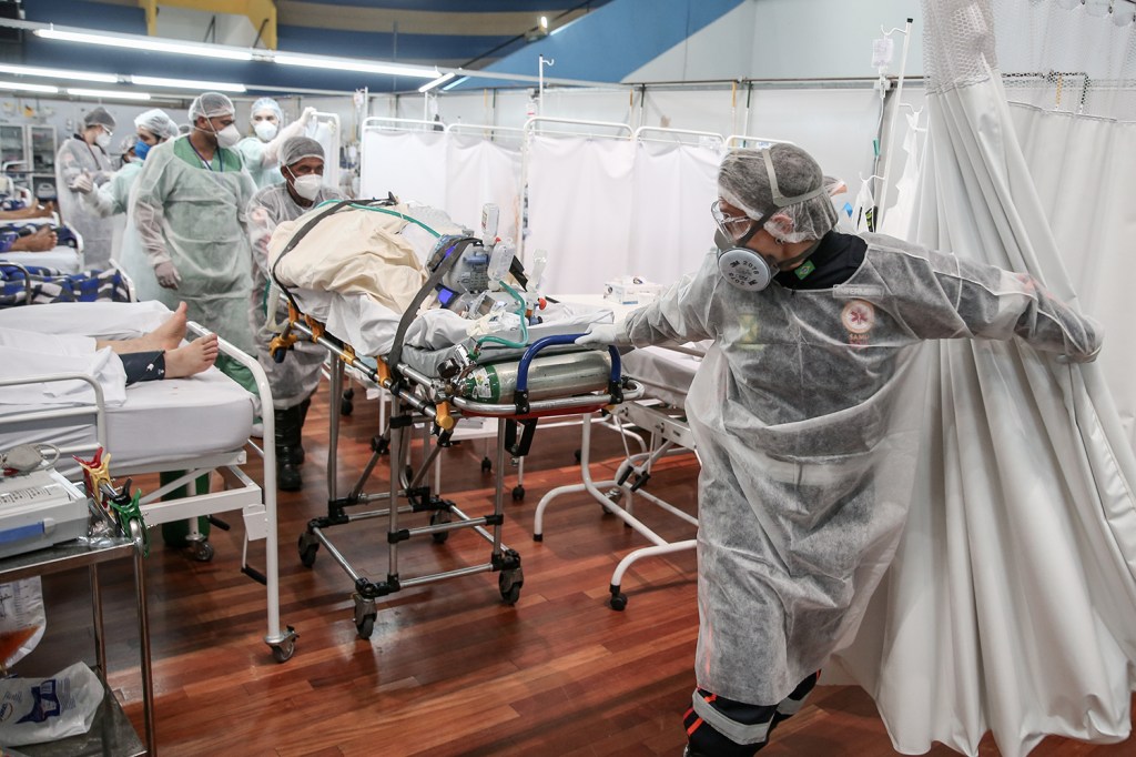 Equipe médica transporta um paciente em uma maca no hospital de campanha do Complexo Esportivo Pedro DellAntonia, em Santo André -
