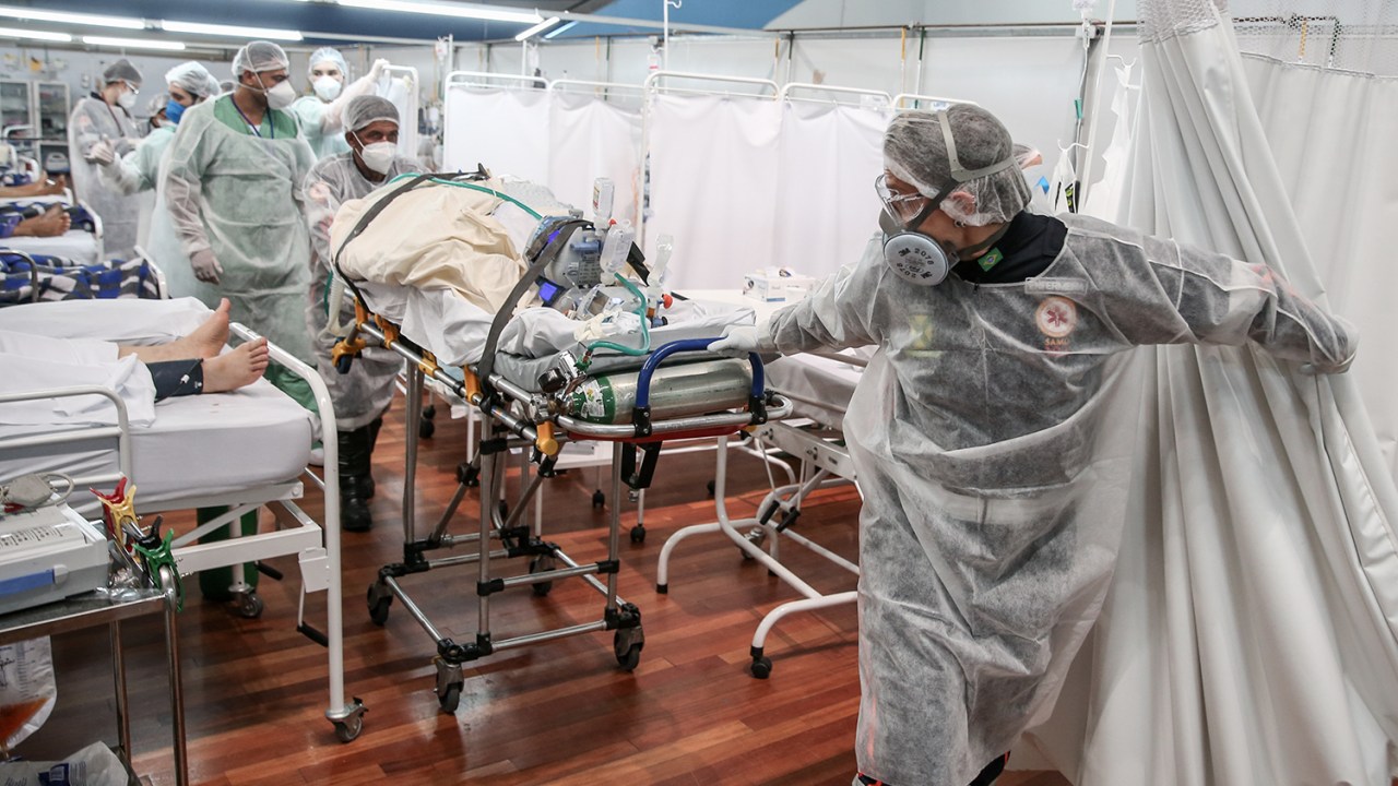 Equipe médica transporta um paciente em uma maca no hospital de campanha do Complexo Esportivo Pedro DellAntonia, em Santo André -