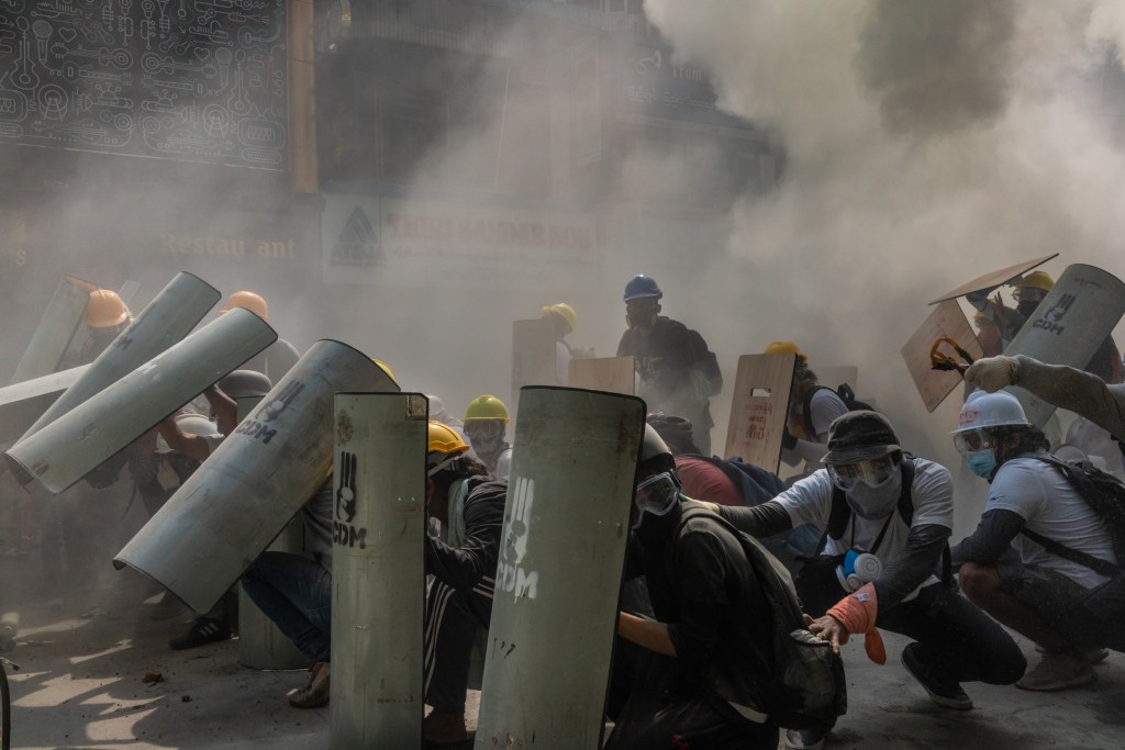 Manifestantes se defendem de bombas de gás lacrimogêneo em Yangon, Mianmar Myanmar - 28/02/2020