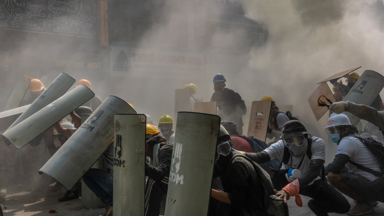 Manifestantes se defendem de bombas de gás lacrimogêneo em Yangon, Mianmar Myanmar - 28/02/2020