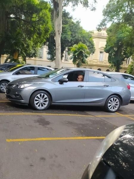 O PN Fabrício Queiroz, dentro de um carro, no estacionamento do Palácio Guanabara