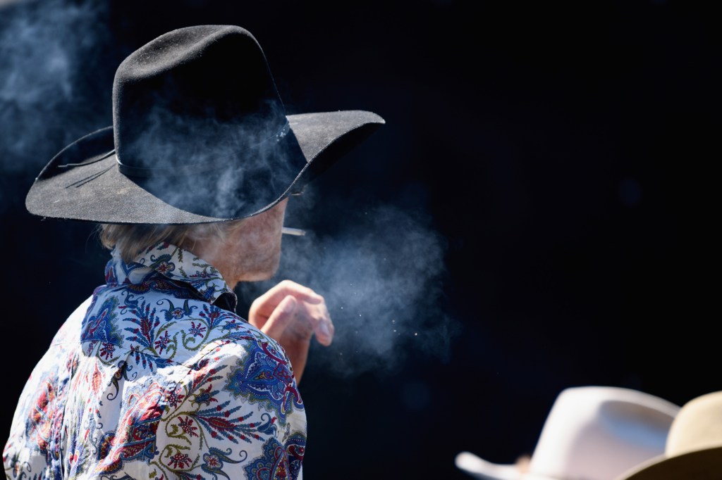 Competidor fuma cigarro durante rodeio em Methven, Nova Zelândia. 21/10/2018