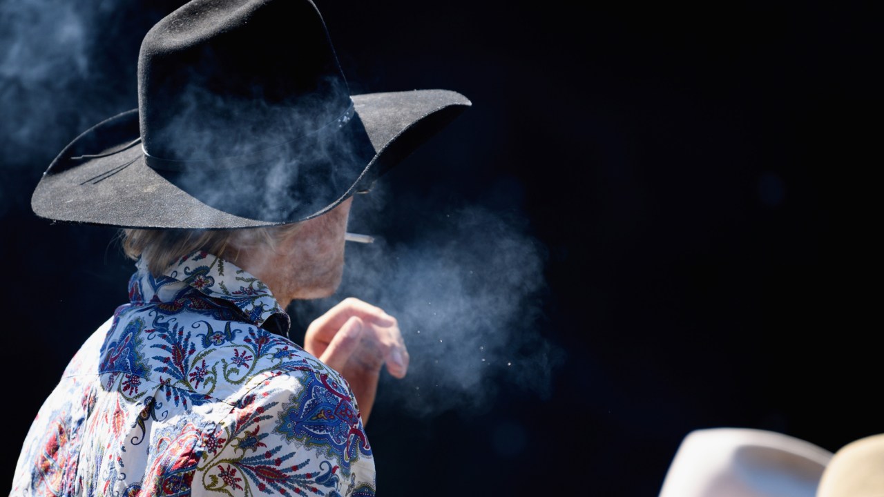 Competidor fuma cigarro durante rodeio em Methven, Nova Zelândia. 21/10/2018
