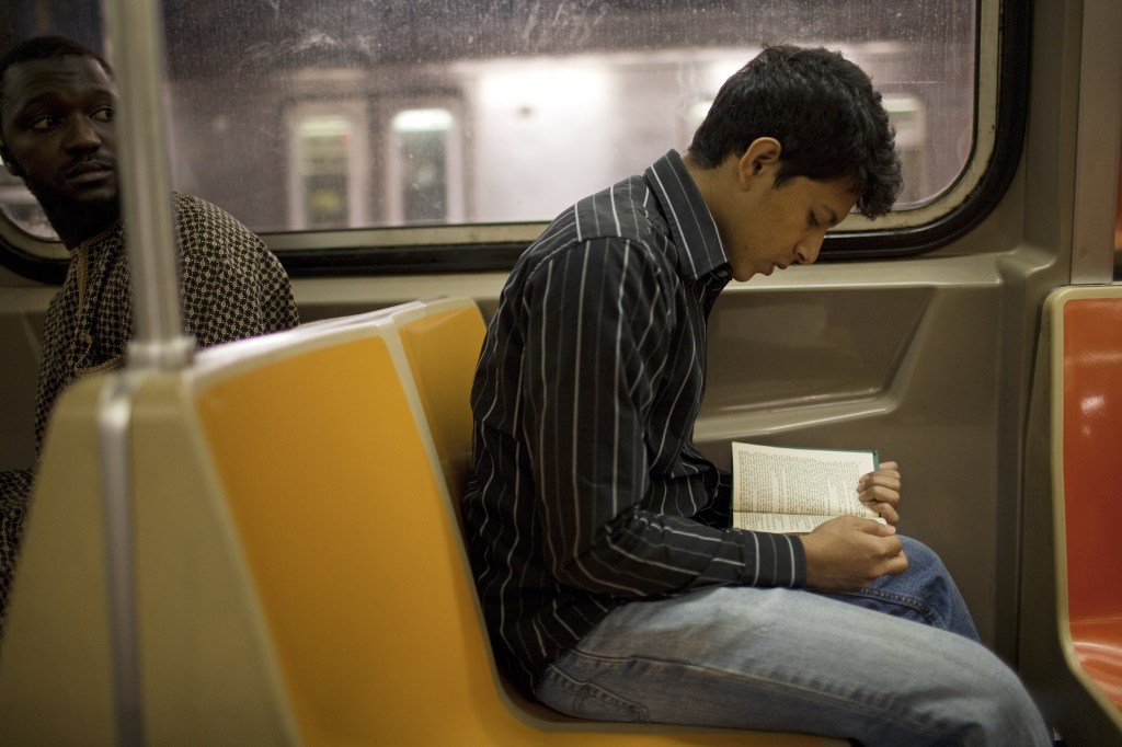 Jovem lendo livro no metrô