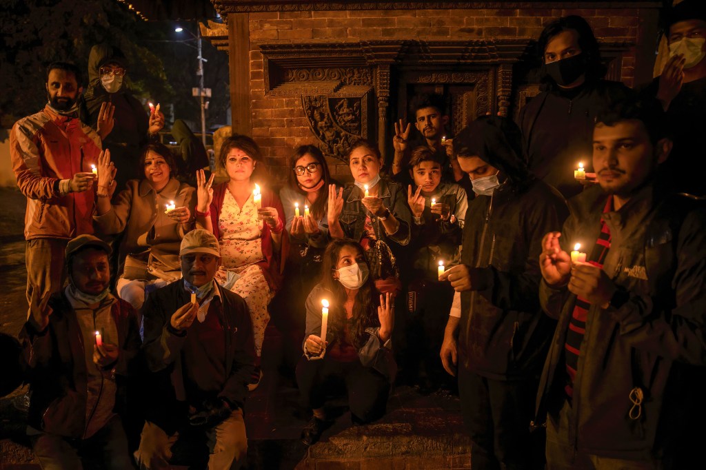 KATHMANDU, NEPAL - 2021/03/31: Protesters holding burning candles while making the three-finger salute attends a candlelight vigil for those who died in protests during Myanmar's military coup at the Premises of Basantapur Durbar Square, a UNESCO world heritage site.Protest against the military coup and the ongoing violence in Myanmar. (Photo by Prabin Ranabhat/SOPA Images/LightRocket via Getty Images)