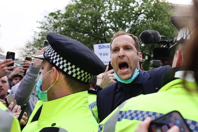 O ex-goleiro do Chelsea, Petr Cech, pede calma enquanto os torcedores se reúnem para protestar contra a introdução da Superliga Europeia, em Londres -