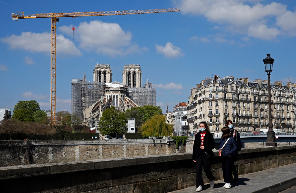 Pedestres com máscaras caminham perto da Notre Dame, em Paris. 13/04/2021
