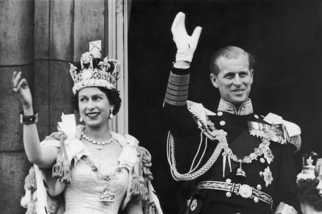 A rainha Elizabeth II e o duque de Edimburgo acenam para a multidão na varanda do Palácio de Buckingham, em 1958 -