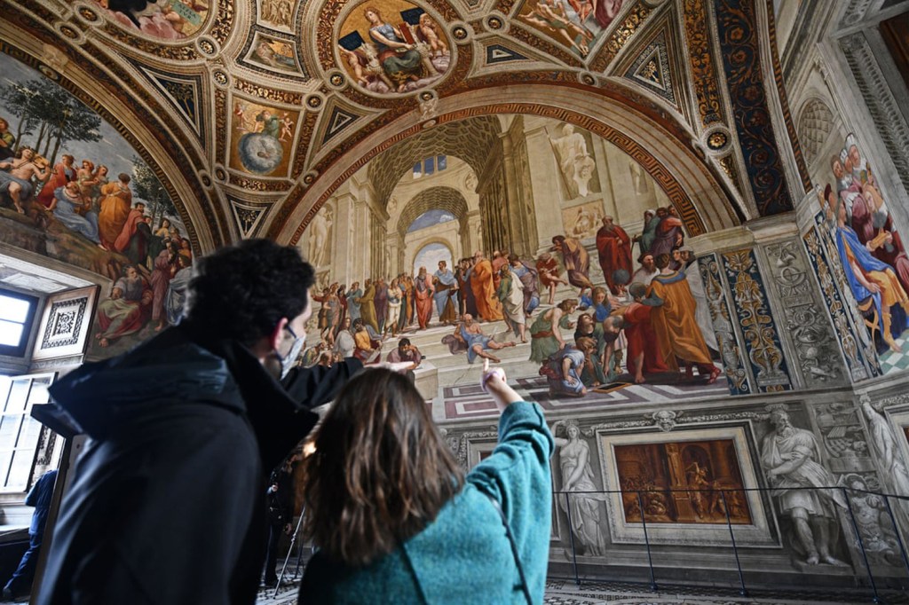 Turistas em visita às salas de Rafael no Vaticano, na Itália