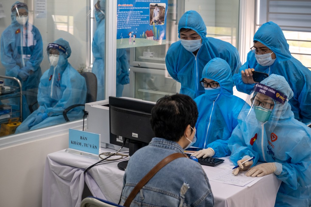 Profissionais de saúde coletam informações de um receptor de vacina AstraZeneca Covid-19 antes da vacinação no Hospital Nacional para Doenças Tropicais em 8 de março de 2021 em Hanói, Vietnã. O Vietnã iniciou seu programa de vacinação Covid-19 na segunda-feira, usando a vacina AstraZeneca desenvolvida pela Universidade de Oxford.