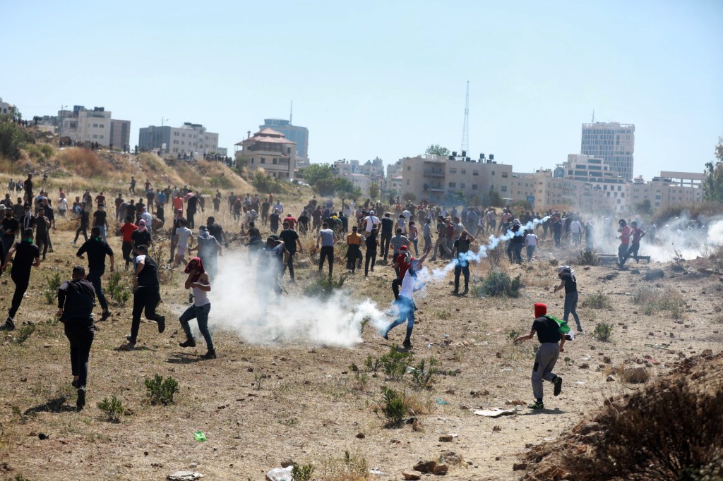 Palestinos respondem à intervenção israelense enquanto se reúnem para encenar um protesto contra os ataques israelenses na Faixa de Gaza e as violações em Jerusalém Oriental. Cisjordânia, 18 de maio de 2021.