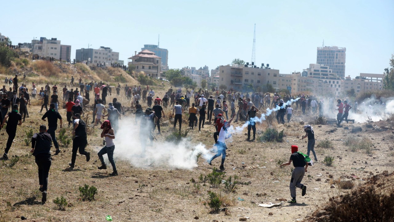 Palestinos respondem à intervenção israelense enquanto se reúnem para encenar um protesto contra os ataques israelenses na Faixa de Gaza e as violações em Jerusalém Oriental. Cisjordânia, 18 de maio de 2021.