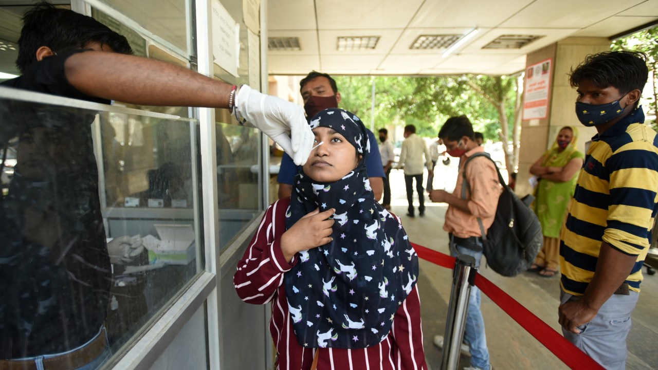 Um trabalhador de saúde coleta uma amostra com o swab o teste Covid-19, em um hospital distrital no Setor 30, em 28 de maio de 2021 em Noida, Índia. (Foto de Sunil Ghosh / Hindustan Times via Getty Images)
