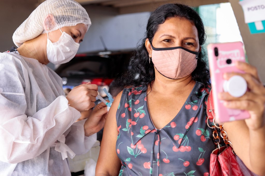 Mulher registra o momento em que é vacinada em Manaus