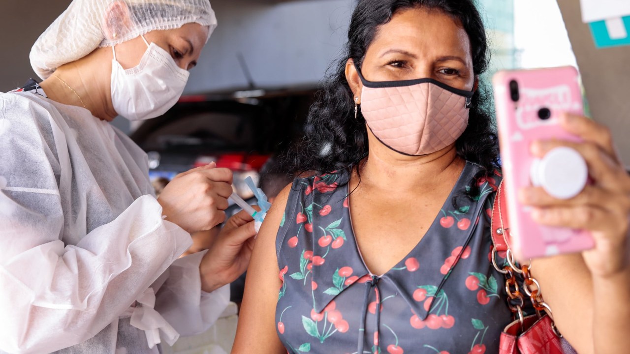 Mulher registra o momento em que é vacinada em Manaus