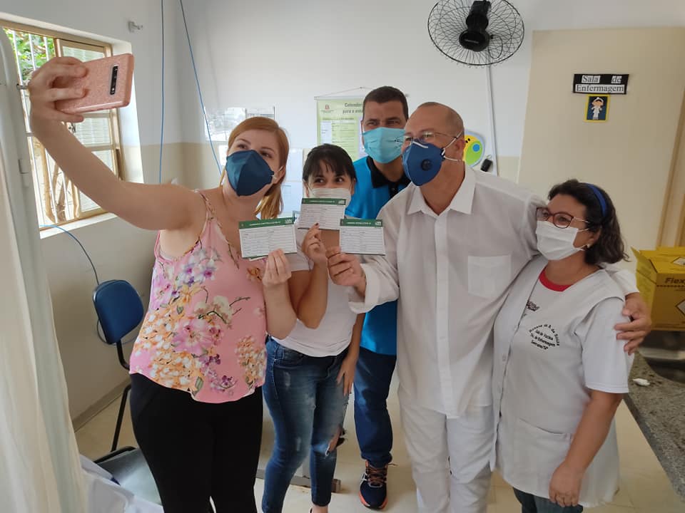 Moradores de Serrana (SP) exibem suas cadernetas de vacinação após serem imunizados