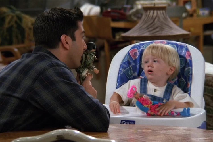 Ross (David Schwimmer) tenta convencer Ben a trocar a boneca Barbie por um soldado, na série 'Friends'